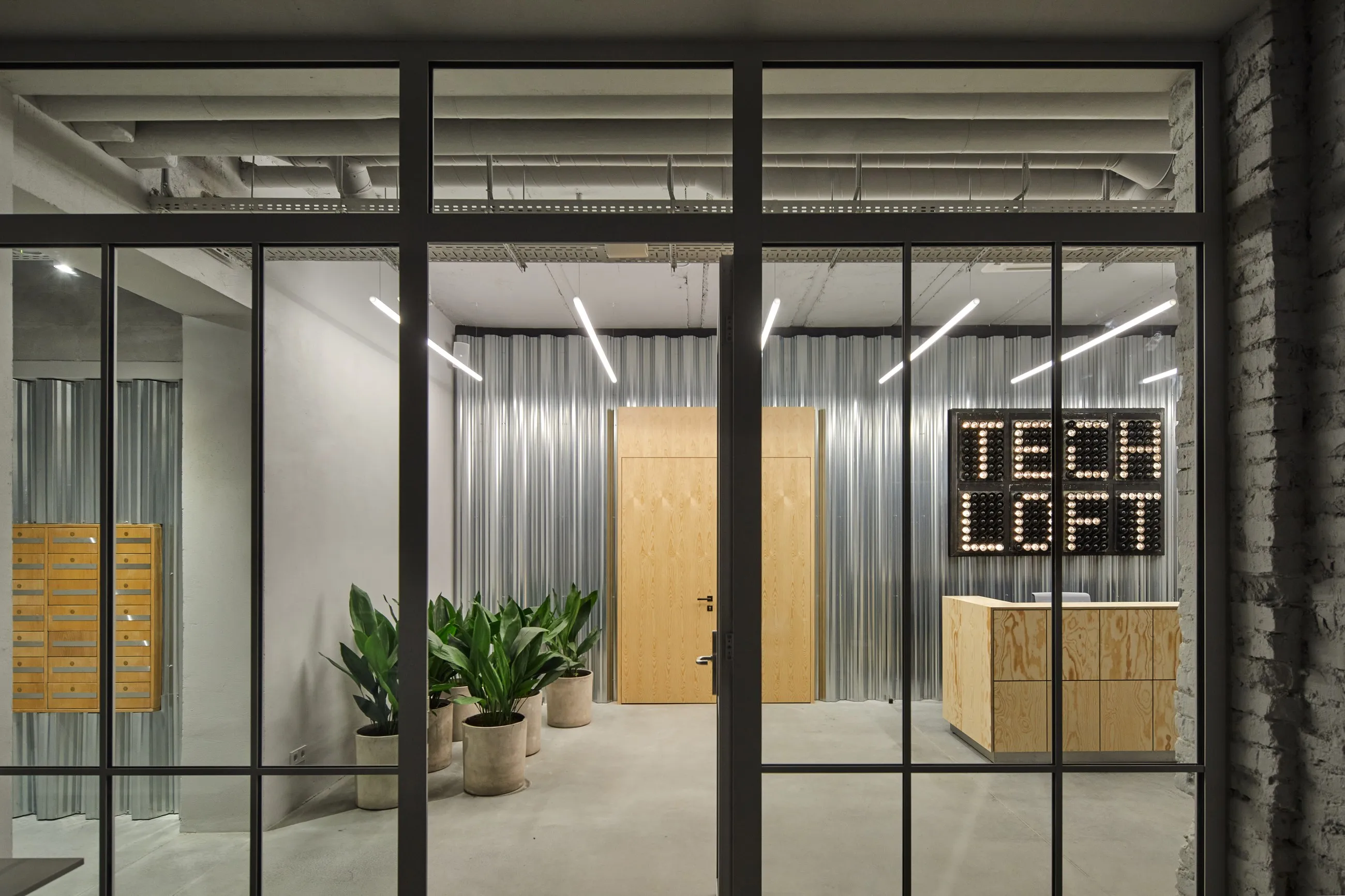 Tech Loft registratūra su švieselių ženklu ir gofruoto metalo siena